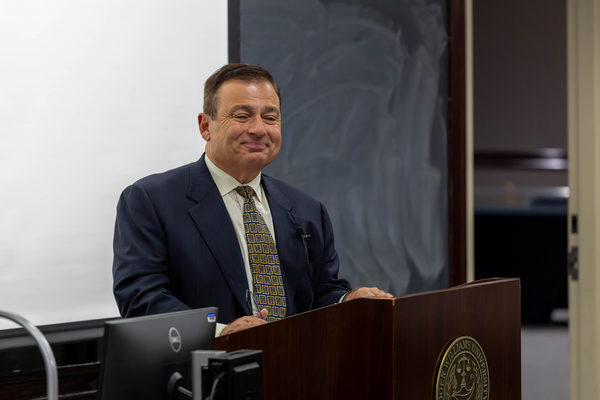 Speaker of the House K. Joseph Shekarchi smiling with the podium in front of him.