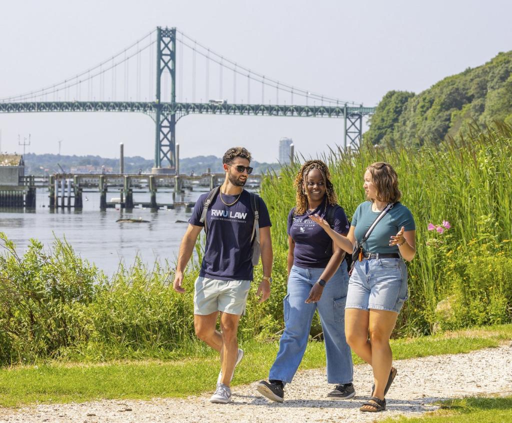 Three students walking down a shell path
