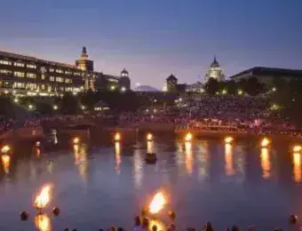 Waterfire Basin in down-city Providence. Several fires in the water basin with the city in the backdrop.