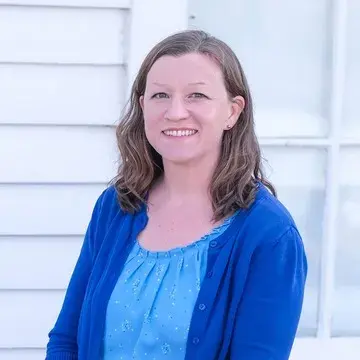 Tracy Harper L'13 smiling before the camera