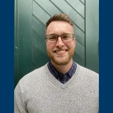 Medium shot of male wearing eyeglasses and a sweater  