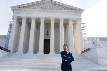 Image of Saad Ahmad L'00 RWU Law alumni in front of the US Supreme Courtrt