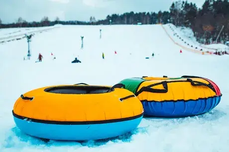 Snow tubing rings close up. Snow covered hill in background.