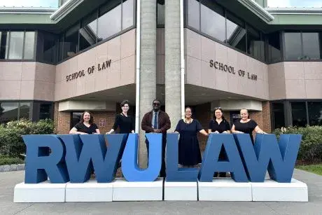 Law Library Staff in front of RWU Law School with lifesize letters "RWULAW"