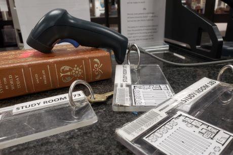 Library book, barcode scanner, and study room door keyes