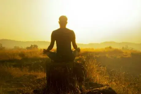 Silhouette of person meditation at sunrise