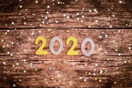 Photograph of the number 2020 with star confetti on a wooden background