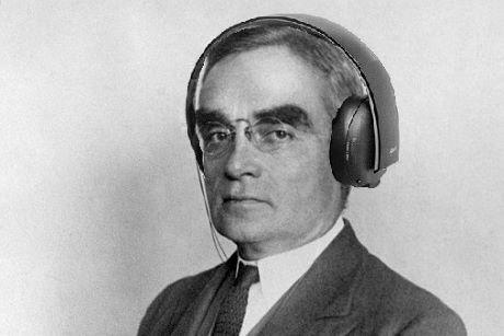 Older man in a suit wearing headphones