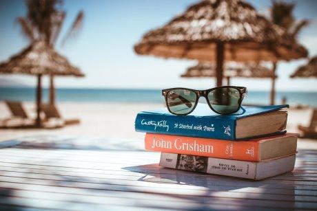 glasses on book at a tropical beach