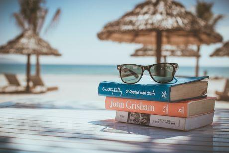 Black sunglasses on top of books at a beach