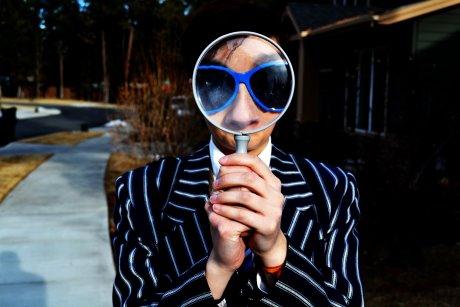 Man looking through magnifying glass