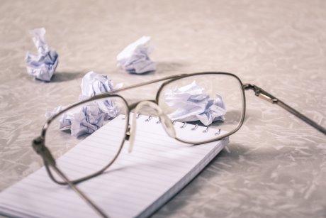 Pair of glasses on a pad of paper