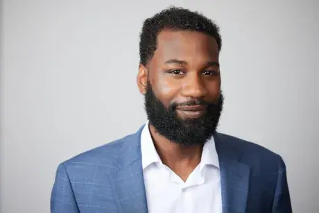 Story subject medium shot wearing a light blue blazer with white collared shirt.