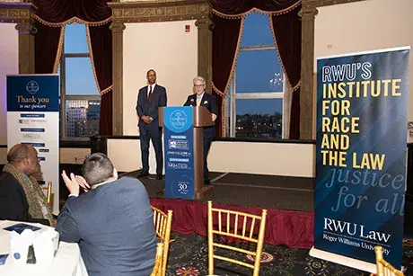 School of Law Dean Gregory W. Bowman speaks at a podium at the Champions for Justice event