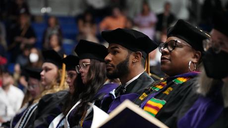 Law graduates listen to ceremony.