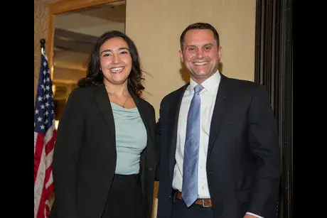 Female wearing a dark jacket and male wearing jacket and tie