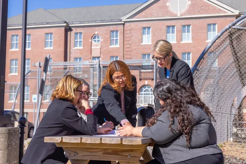 Image of RWU Law students volunteering in the Pro Bono Collaborative (PBC) program at the Adult Correctional Institute (ACI) Civil Legal Assistance are having a discussion with the program directors from RWU Law.