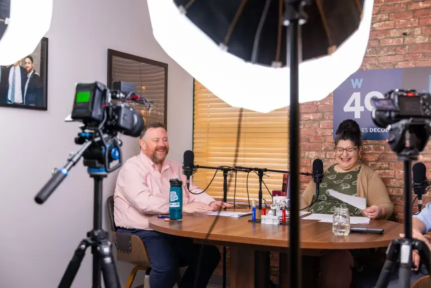 Hosts Nicole and Michael laughing behind the mic of the podcast