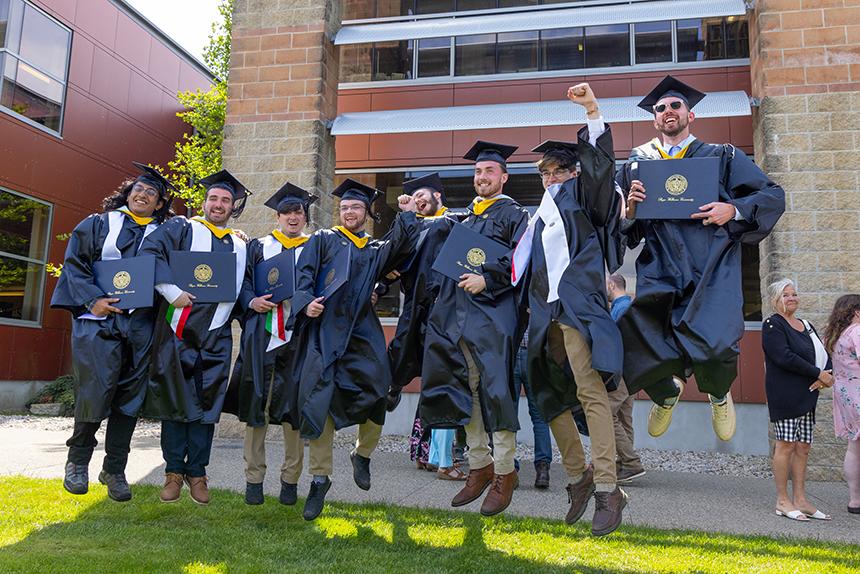 Graduates jump with their degrees